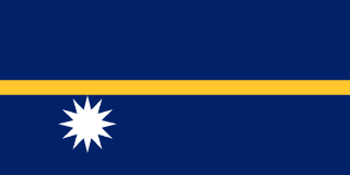 The flag of Nauru has a dark blue field with a thin yellow horizontal band across the center and a large white twelve-pointed star beneath the horizontal band on the hoist side of the field.